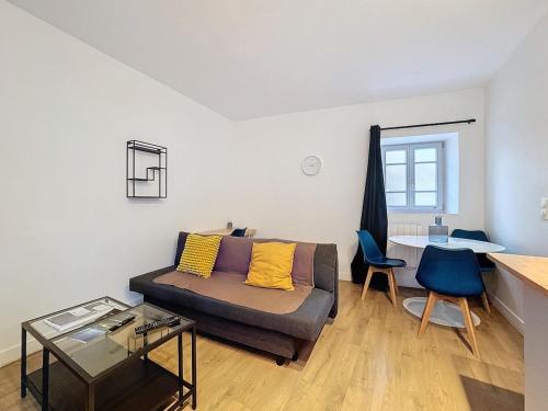 un salon avec un canapé et une table dans l'établissement Appartement cosy près de la gare - 4 pers - Nr1, à Clermont-Ferrand