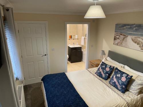a bedroom with a bed and a bathroom with a sink at Nelly's Nest in Bridlington