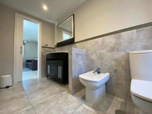 a bathroom with a toilet and a sink and a mirror at Housingcoruña Apartamento Playa Miño 02 in Miño