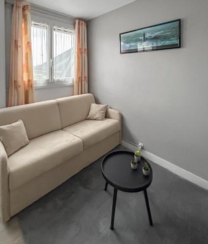 un salon avec un canapé et une table dans l'établissement T2 Cuisine équipée, Parking privé, 4 personnes, à Bayeux