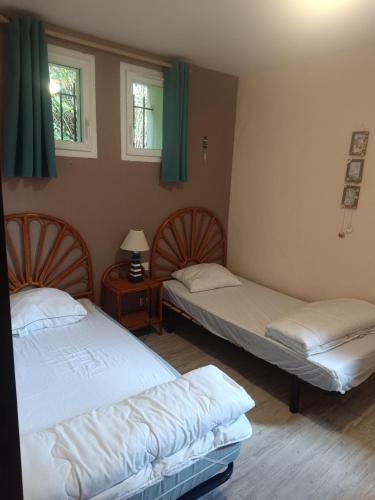 deux lits dans une chambre avec deux fenêtres dans l'établissement appartement, résidence centre ville, Le Tréport, au Tréport