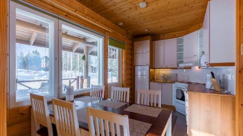 una cocina con mesa y sillas en una cabaña en Lekotti Vacation Club, en Savonranta