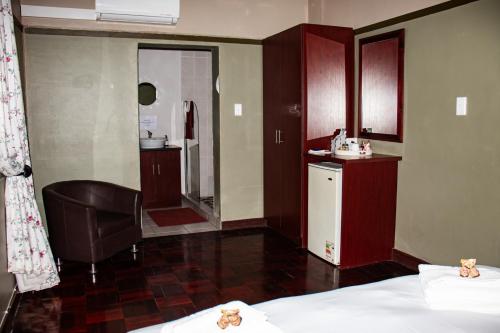 a hotel room with two beds and a bathroom at Colenso Lodge B&B in Colenso