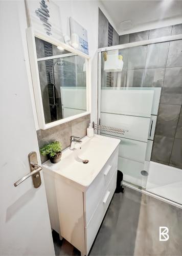 a white bathroom with a sink and a shower at Comfortable house 20 minutes from Paris by RER in Brétigny-sur-Orge
