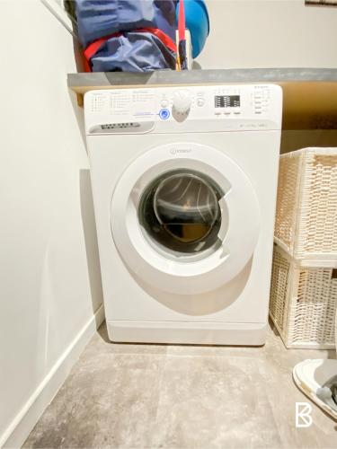a white washing machine sitting in a laundry room at Comfortable house 20 minutes from Paris by RER in Brétigny-sur-Orge