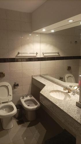 a bathroom with a sink and a toilet and a mirror at Departamento 114 - Edificio VILAUT by INMOVE Temporarios in Córdoba