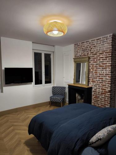 a bedroom with a bed and a brick wall at Le Lambert, à 3 minutes du port et tout à côté du célèbre palais Bénédictine in Fécamp