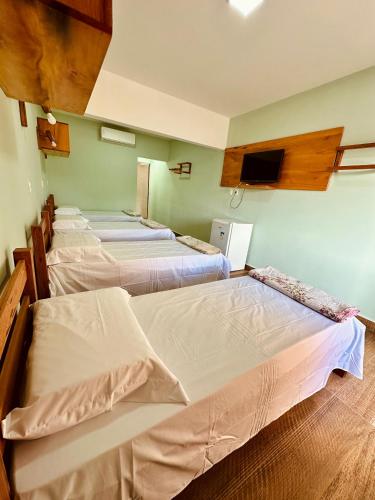 a group of four beds in a room at Pousada Tia Rosa in Parnamirim