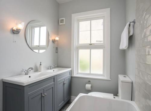 a bathroom with a sink and a toilet and a mirror at Hafan Glyd charming cozy cottage in Conwy in Conwy