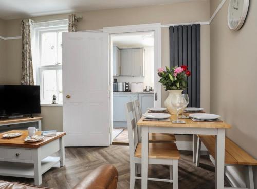 a living room with a table with a vase of flowers at Hafan Glyd charming cozy cottage in Conwy in Conwy