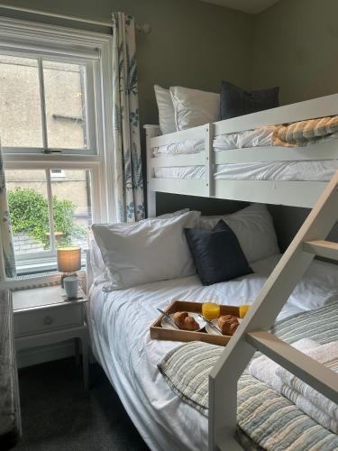 a bedroom with a bunk bed with a tray of food on it at Hafan Glyd charming cozy cottage in Conwy in Conwy