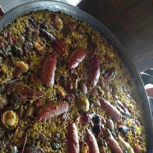 a pizza with bacon and other ingrediants on a pan at El Quesar de Gamoneo in Gamonedo de Cangas