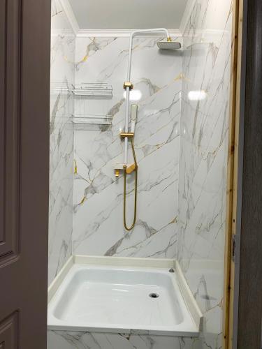 un bagno con vasca e pareti in marmo bianco di Safar a Karakol