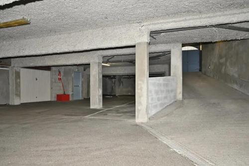 an empty parking garage with concrete pillars in it at Appartement chaleureux à Cauterets - 35 m² - Casier à skis in Cauterets