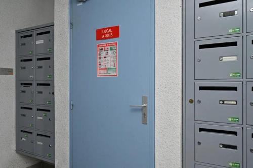 a blue door with a sign on it next to lockers at Appartement chaleureux à Cauterets - 35 m² - Casier à skis in Cauterets