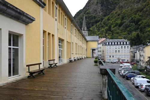 a wooden walkway in a city with buildings and cars at Appartement chaleureux à Cauterets - 35 m² - Casier à skis in Cauterets