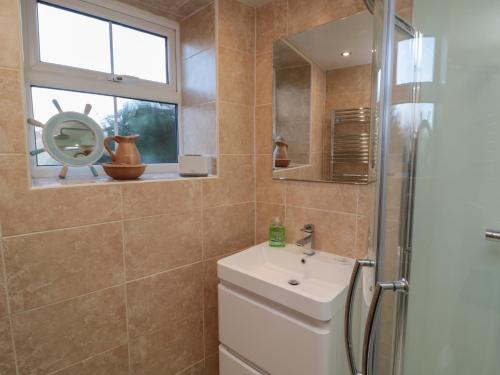 une salle de bain avec toilettes, lavabo et fenêtre dans l'établissement Riverside Cottage, à Warkworth