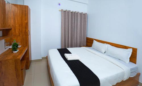 a bedroom with a large white bed in a room at Hr residency in Kozhikode