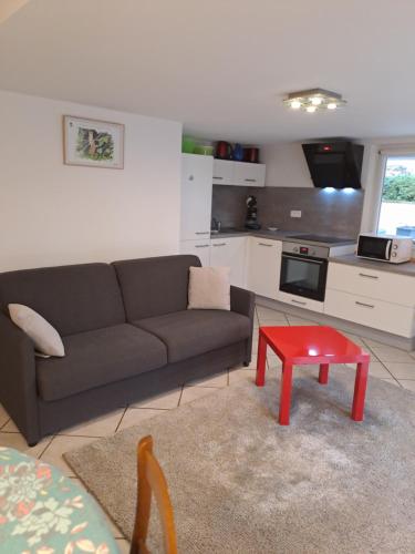 a living room with a couch and a red stool at Gite de la Melch in Reipertswiller