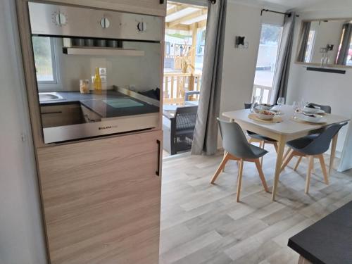 une cuisine et une salle à manger avec une table dans l'établissement mobil home siblu, aux Mathes