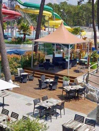 un patio extérieur avec tables, chaises et un parasol dans l'établissement mobil home siblu, aux Mathes