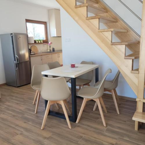 a kitchen and dining room with a table and chairs at Domek Pod Lasem in Czarny Dunajec