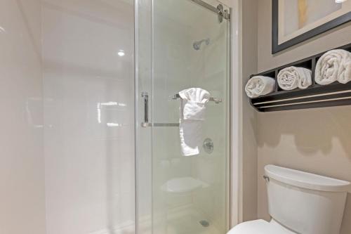 a bathroom with a shower with a toilet and towels at Best Western Plus Lafayette Hotel University Area in Lafayette