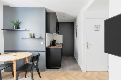 une cuisine et une salle à manger avec une table et des chaises dans l'établissement unwind in timeless comfort, à Paris