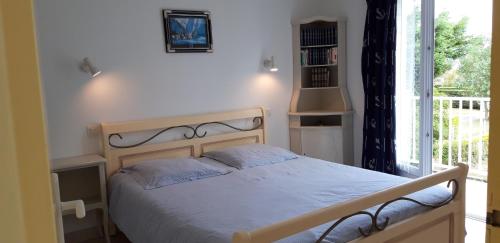 une chambre avec un lit et une grande fenêtre dans l'établissement Le HOME, à Varaville