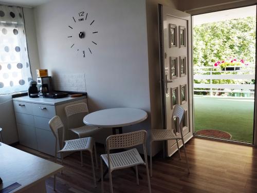 a kitchen with a table and chairs and a clock on the wall at Pokoje Gościnne u Kasi in Międzywodzie