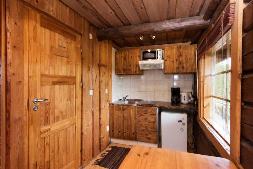 a kitchen with wooden walls and a wooden door at Sokka Holiday Center & Glamping in Otepää