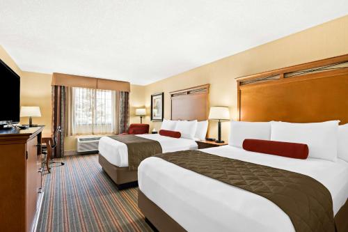 a hotel room with two beds and a flat screen tv at Best Western Newberry Station in La Pine