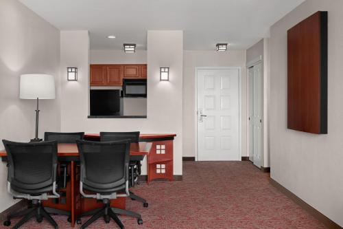 a room with a table and chairs and a kitchen at Larkspur Landing Extended Stay Suites Folsom in Folsom