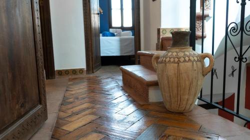 Un jarrón en el suelo de una habitación. en Casa Abuela Ana, en Vélez-Málaga