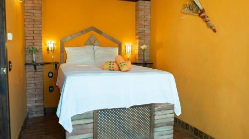 Un dormitorio con una cama grande con una pared naranja. en Casa Abuela Ana, en Vélez-Málaga