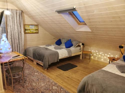 a bedroom with two beds and a table and a desk at Noclegi Święta Katarzyna ,, Pod Jeleniami "prawdziwymi in Święta Katarzyna
