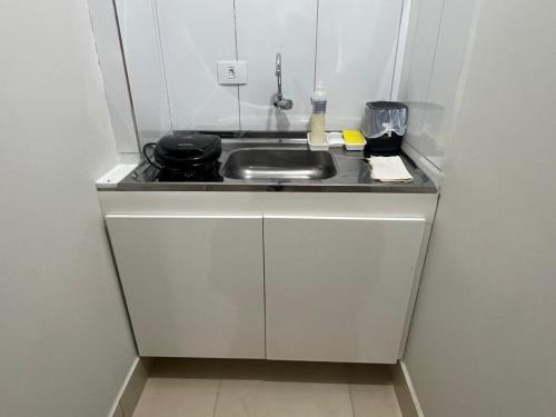 a small kitchen with a sink and a stove at Studio 38 - Próx ao Parque do Sabiá Aeroporto e Shopping in Uberlândia