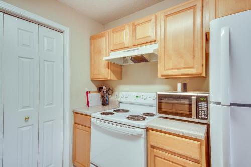 a kitchen with a stove and a white refrigerator at Birding, Beaches and More Cozy Gautier Condo in Gautier