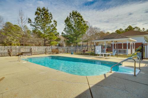 a swimming pool in a yard with a fence at Birding, Beaches and More Cozy Gautier Condo in Gautier