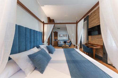 a bedroom with a large bed with blue and white pillows at La Casa Azul Boutique Hotel in Andújar