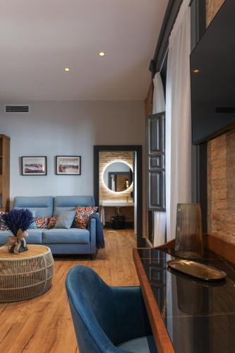 a living room with a blue couch and a mirror at La Casa Azul Boutique Hotel in Andújar
