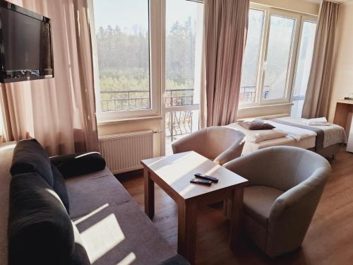 a living room with a couch and chairs and a tv at Wodnik Turawa in Turawa