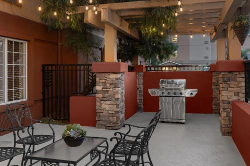 ミルピータスにあるLarkspur Landing Extended Stay Suites Milpitasの屋外パティオ(テーブル、椅子、グリル付)