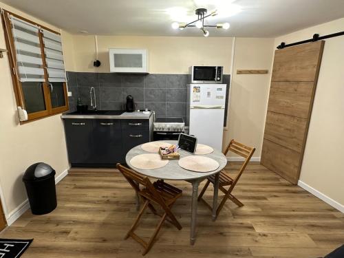 une cuisine avec une table et des chaises dans une cuisine dans l'établissement Maison Mers les bains, à Mers-les-Bains