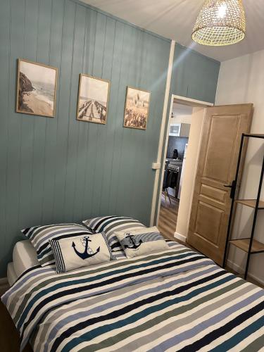 une chambre avec un lit à rayures bleues et blanches dans l'établissement Maison Mers les bains, à Mers-les-Bains