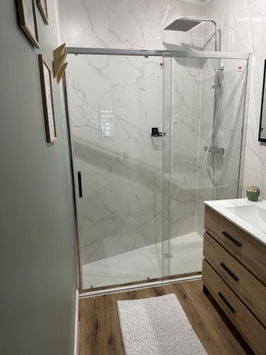 une douche avec une porte vitrée dans une salle de bain dans l'établissement Maison Mers les bains, à Mers-les-Bains