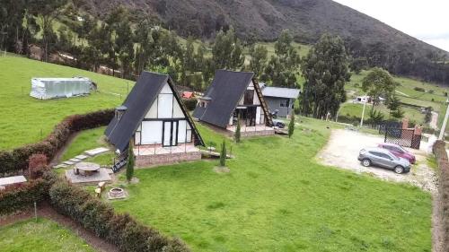 an aerial view of a house on a green field at Cabañas Aiyana in Guatavita