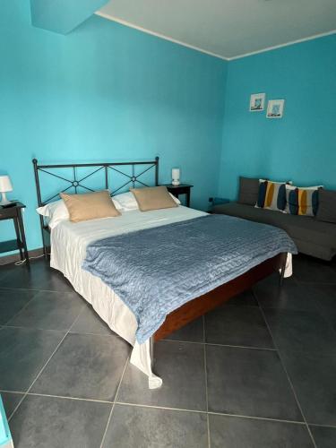 a bedroom with a large bed and a couch at B&B Terrazza dell'Etna in Mascalucia