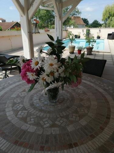 un vase de fleurs assis sur une table dans l'établissement Appartement dans village médiéval, à Sauveterre