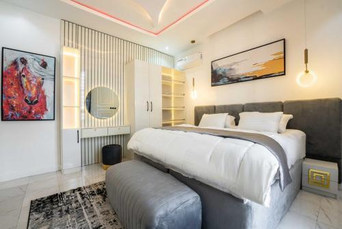 una camera da letto con un letto grande e un divano di 247 Electricity 2 bedrooms Lux Ikate with PS5 opt a Lekki